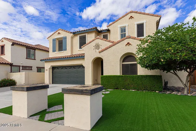 a front view of a house with a garden and yard