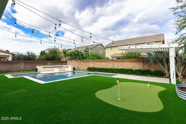 a swimming pool with outdoor seating and yard