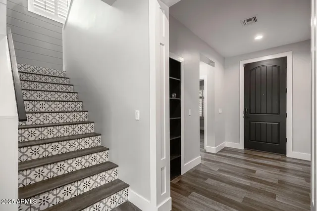 a view of a hallway with wooden floor and staircase