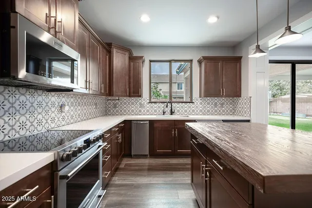 a kitchen with stainless steel appliances granite countertop a sink stove and microwave