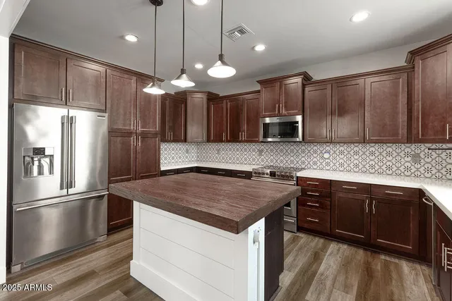 a kitchen with a center island wooden cabinets and stainless steel appliances