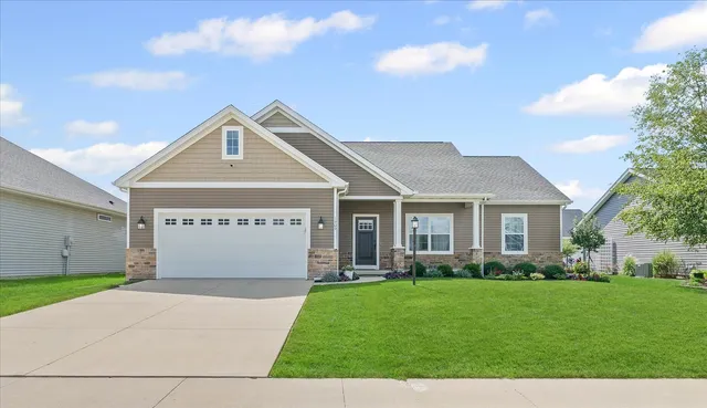 a front view of a house with a garden and plants