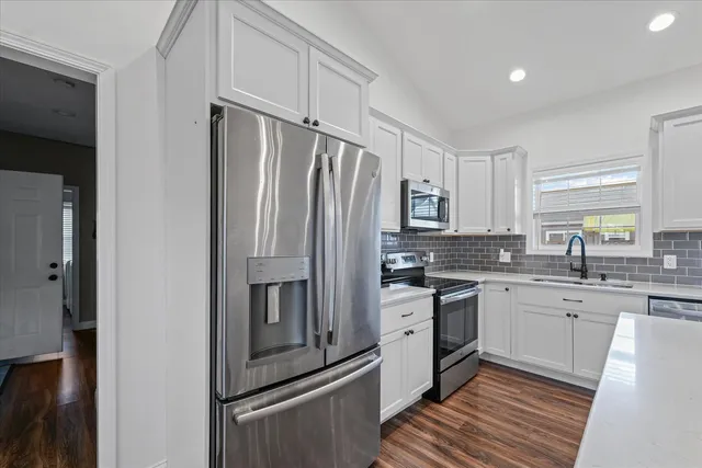 a kitchen with stainless steel appliances a refrigerator sink and cabinets
