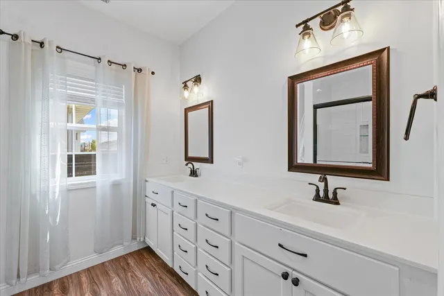 a bathroom with a double vanity sink and a mirror