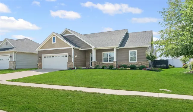 a view of a house with a big yard and a large tree