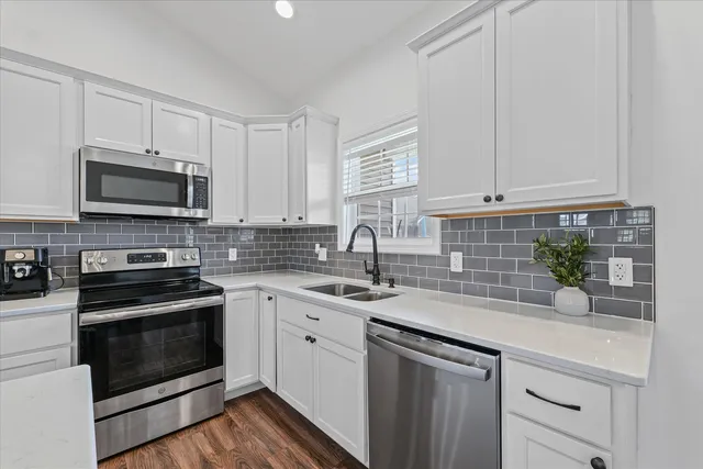 a kitchen with appliances a sink and cabinets
