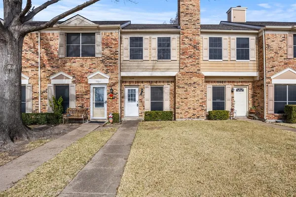 front view of a brick house with a yard
