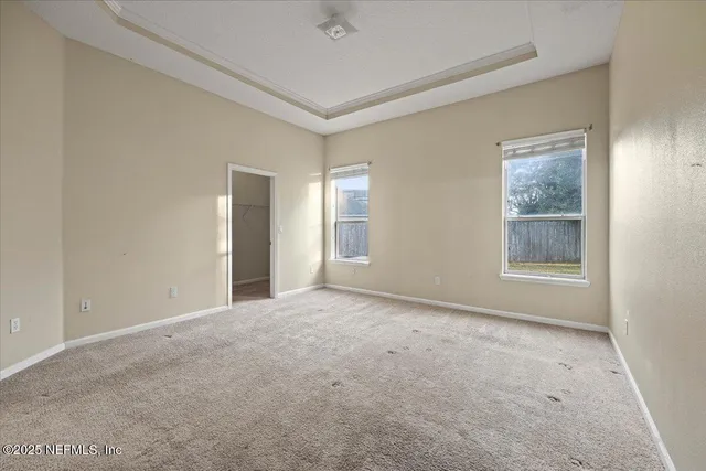 a view of an empty room with window and closet area