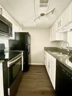 a kitchen with stainless steel appliances granite countertop a refrigerator a stove and a sink