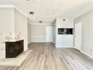a view of empty room with wooden floor and fireplace