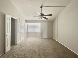 a view of an empty room with a chandelier fan