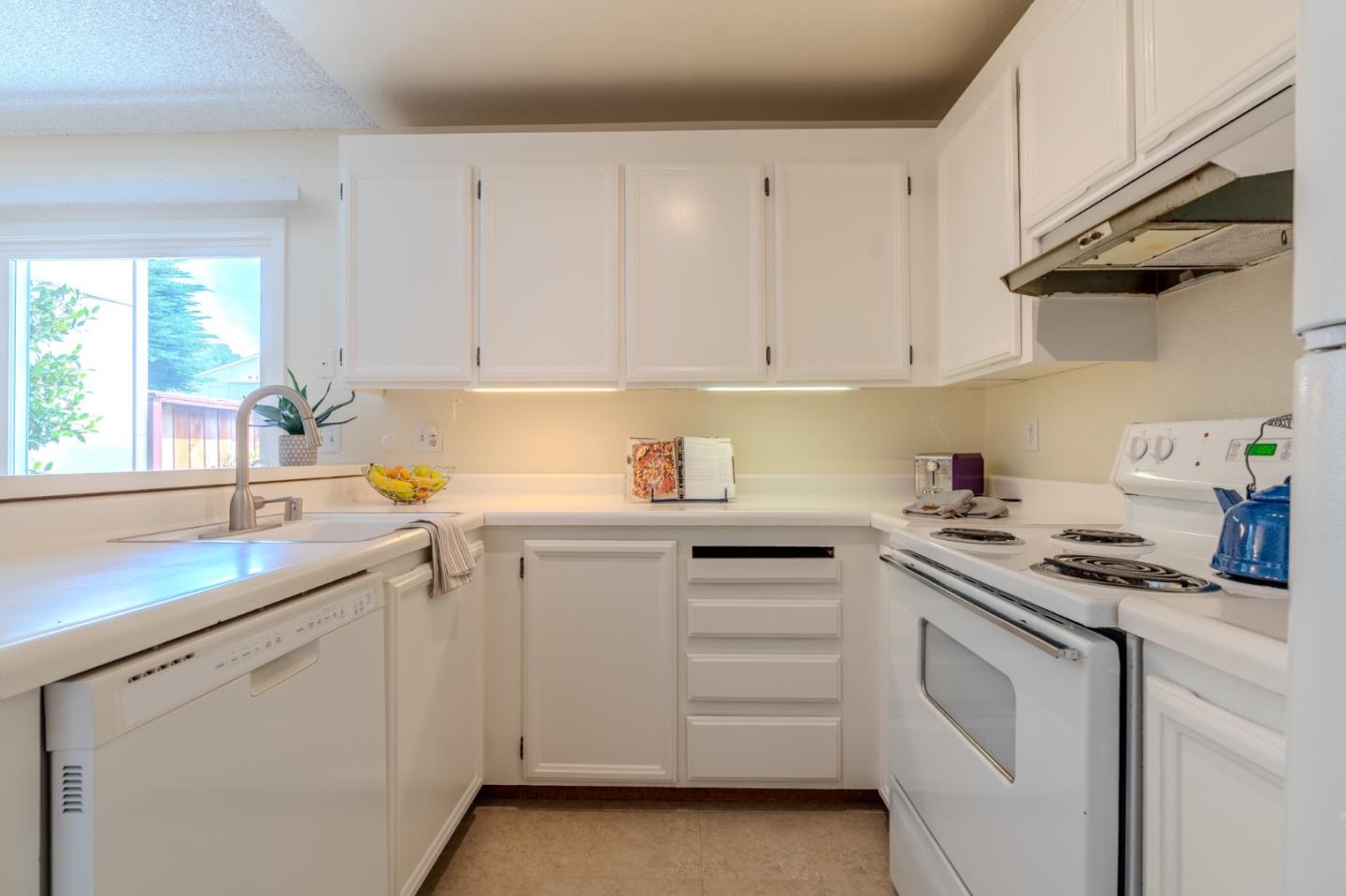 1263 Rosita Road Pacifica, CA 94044 - Photo 13 of 37 a kitchen with white cabinets and white appliances