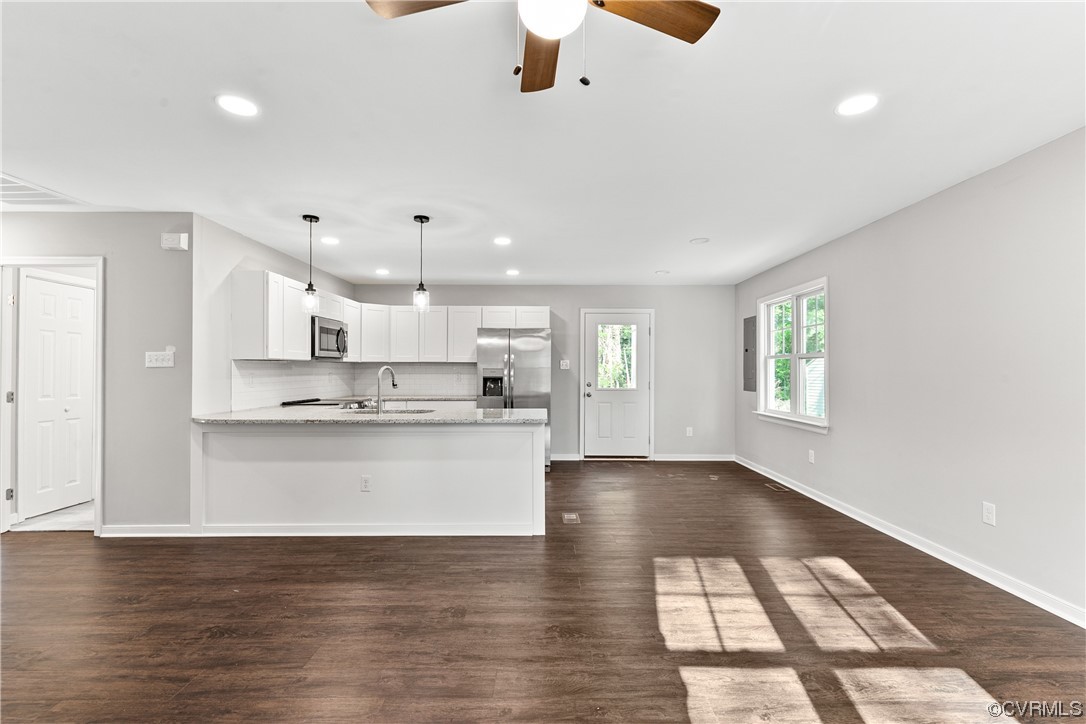 15406 Saddlebrook Road Chesterfield, VA 23838 - Photo 5 of 36 a large white kitchen with kitchen island a stove a sink dishwasher and white cabinets with wooden floor
