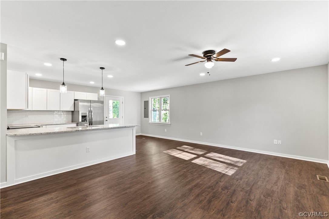 15406 Saddlebrook Road Chesterfield, VA 23838 - Photo 6 of 36 a kitchen with granite countertop a stove a sink and white cabinets with wooden floor