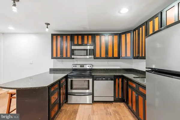 a kitchen with granite countertop a stove a sink and a refrigerator