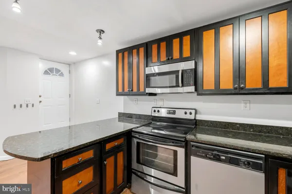 a kitchen with stainless steel appliances a stove sink microwave and cabinets