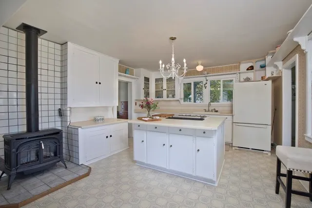a dining room with chandelier and wooden floor