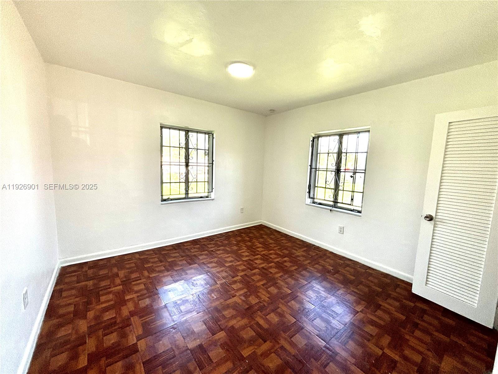 2145 Northwest 64th Street Miami, FL 33147 - Photo 14 of 21 an empty room with wooden floor and windows