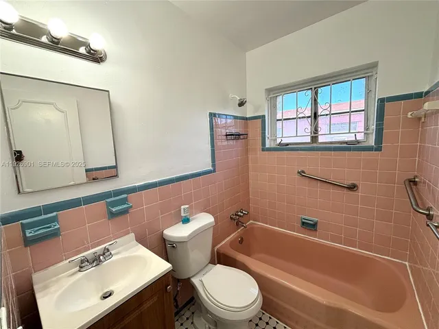 a bathroom with a toilet a sink and mirror