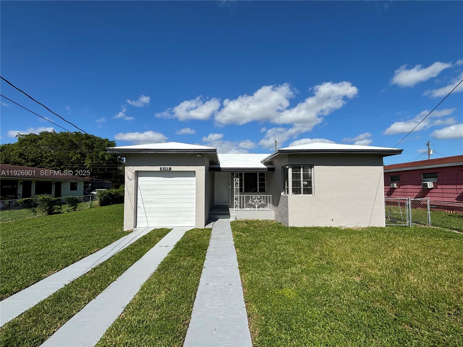 2145 Northwest 64th Street Miami, FL 33147 - Photo 2 of 21 a front view of a house with a yard and garage
