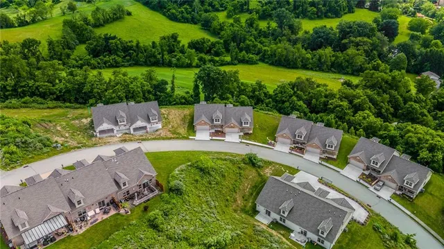 an aerial view of a house with a garden and lake view