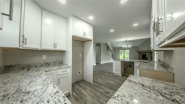 a kitchen with stainless steel appliances kitchen island granite countertop a refrigerator and cabinets