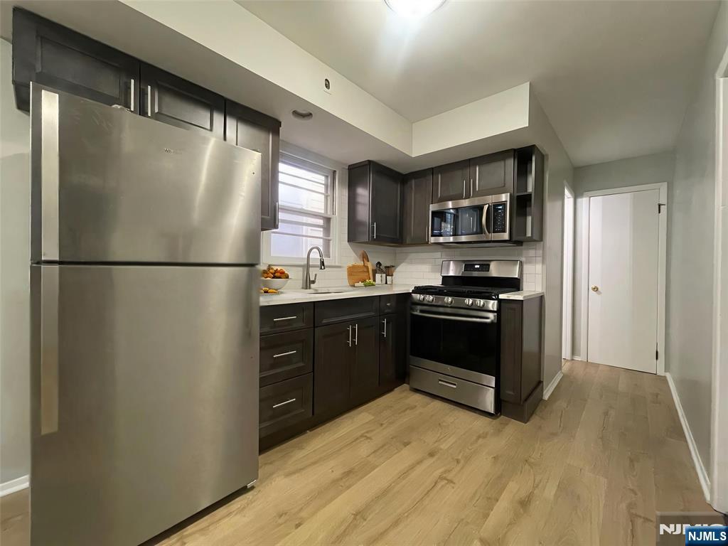319 Hamilton Street, Unit 2 Harrison, NJ 07029 - Photo 3 of 7 a kitchen with a refrigerator and a stove top oven