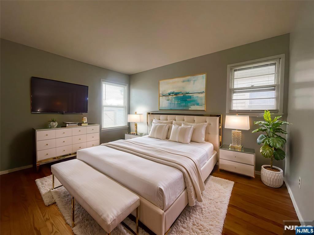 319 Hamilton Street, Unit 2 Harrison, NJ 07029 - Photo 5 of 7 a bedroom with a bed and a flat screen tv