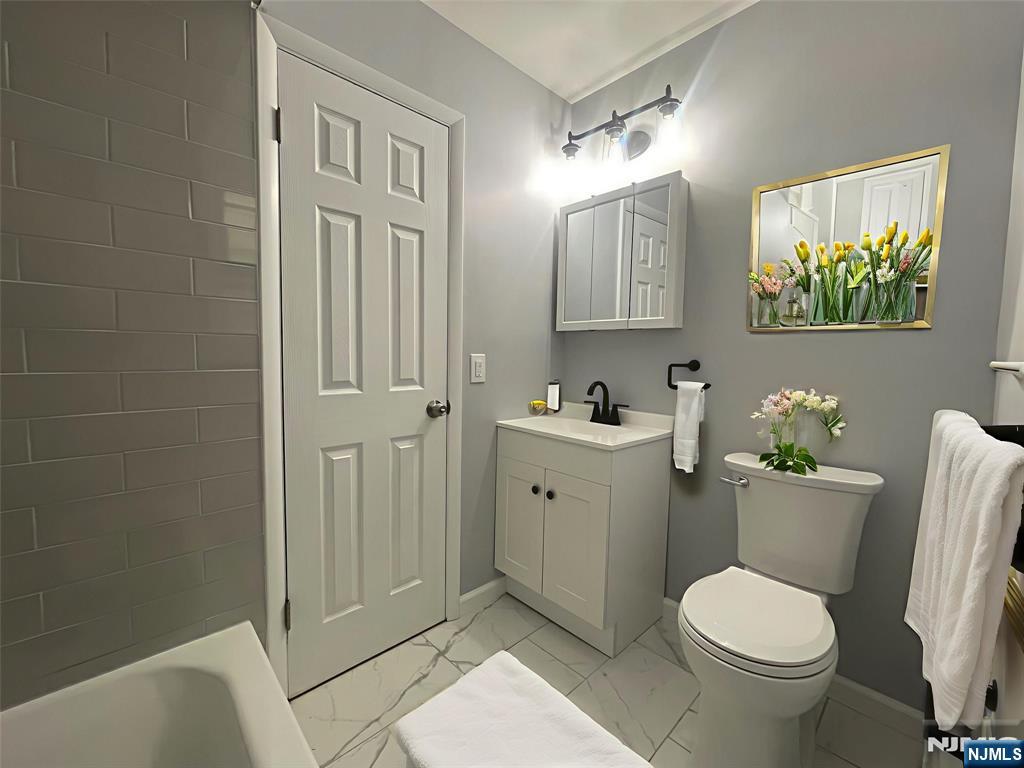 319 Hamilton Street, Unit 2 Harrison, NJ 07029 - Photo 6 of 7 a bathroom with a toilet sink and mirror