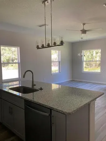 a kitchen with a granite countertop sink window and refrigerator