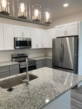 a kitchen with stainless steel appliances granite countertop a sink stove and microwave
