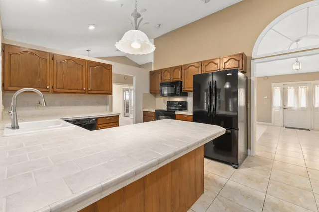 a kitchen with stainless steel appliances granite countertop a sink refrigerator and cabinets