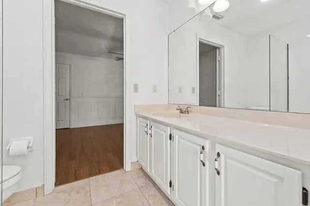 a bathroom with a granite countertop sink a toilet and a shower