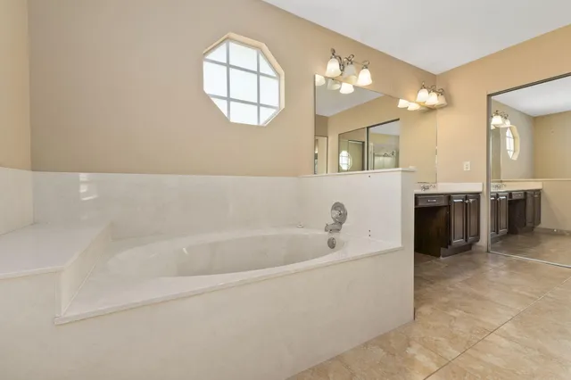 a spacious bathroom with a bathtub and a sink