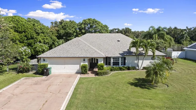 a view of a house with backyard and trees