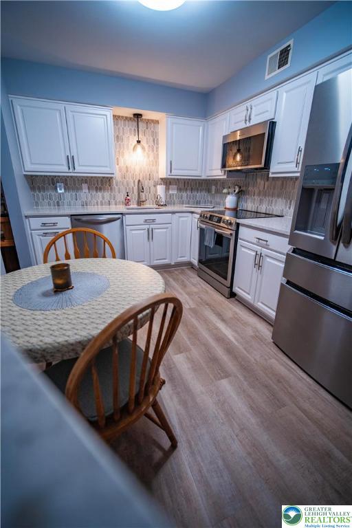 443 Vera Circle, Unit K Bethlehem, PA 18017 - Photo 6 of 24 a kitchen with granite countertop a stove top oven a sink dishwasher a dining table and chairs with wooden floor