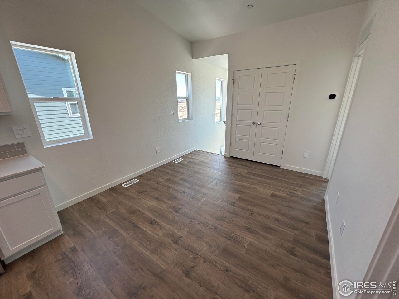 3716 Pinnacles Court Evans, CO 80620 - Photo 3 of 9 a view of an empty room with wooden floor and a window