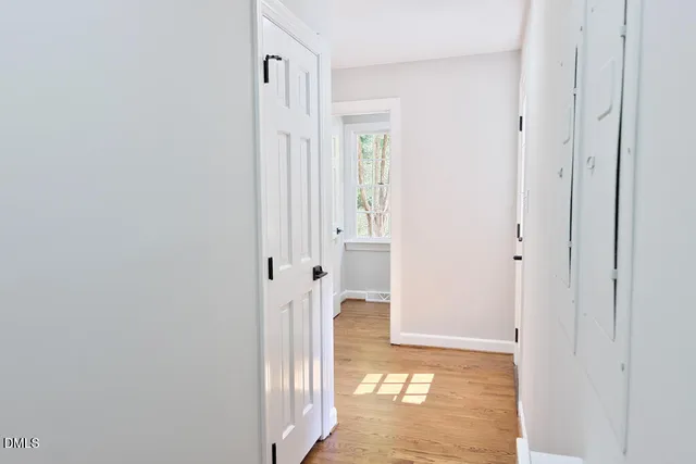 an empty room with windows and ceiling fan
