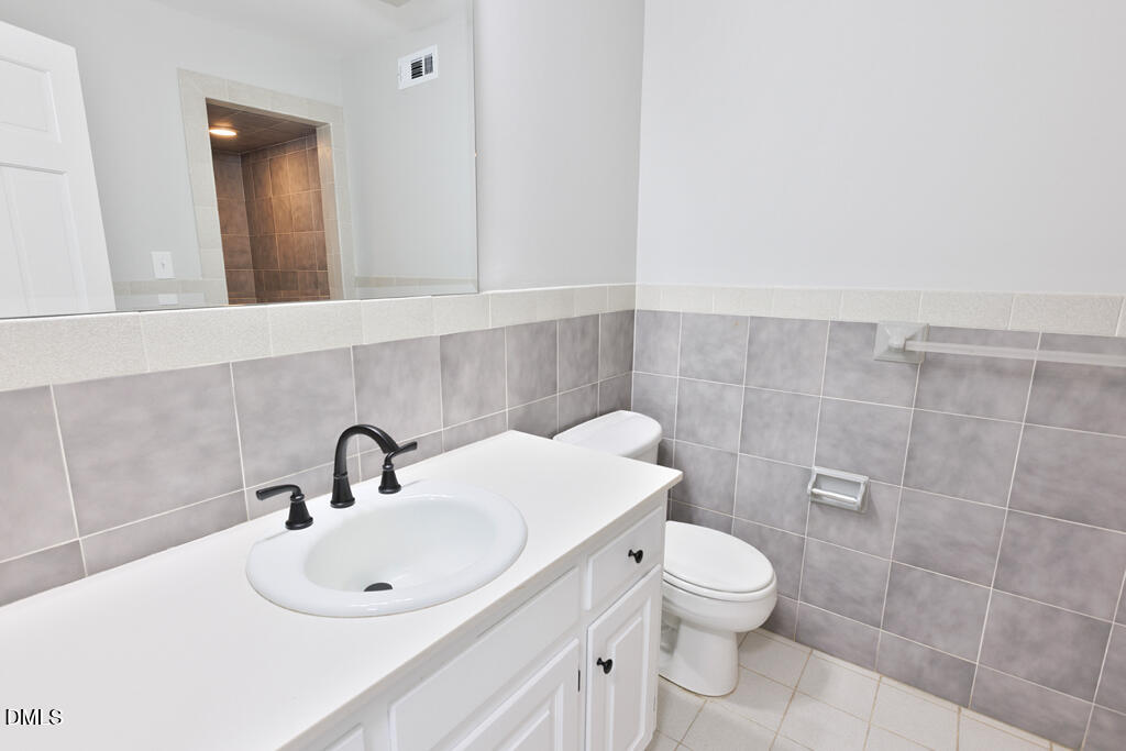 14263 Wyndfield Circle Raleigh, NC 27615 - Photo 72 of 74 a bathroom with a toilet sink and mirror