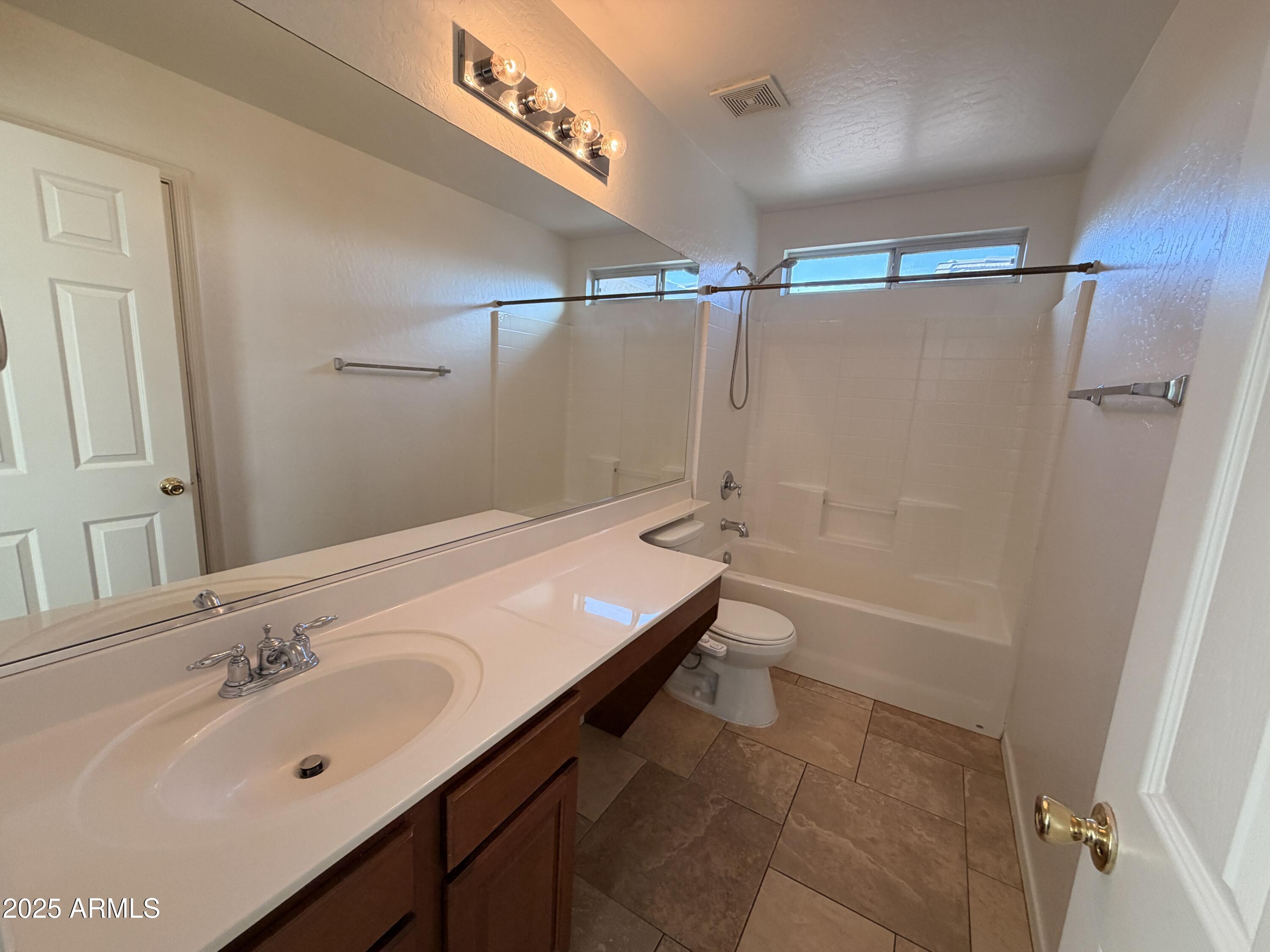 10027 West Payson Road Tolleson, AZ 85353 - Photo 15 of 18 a bathroom with a tub sink and mirror