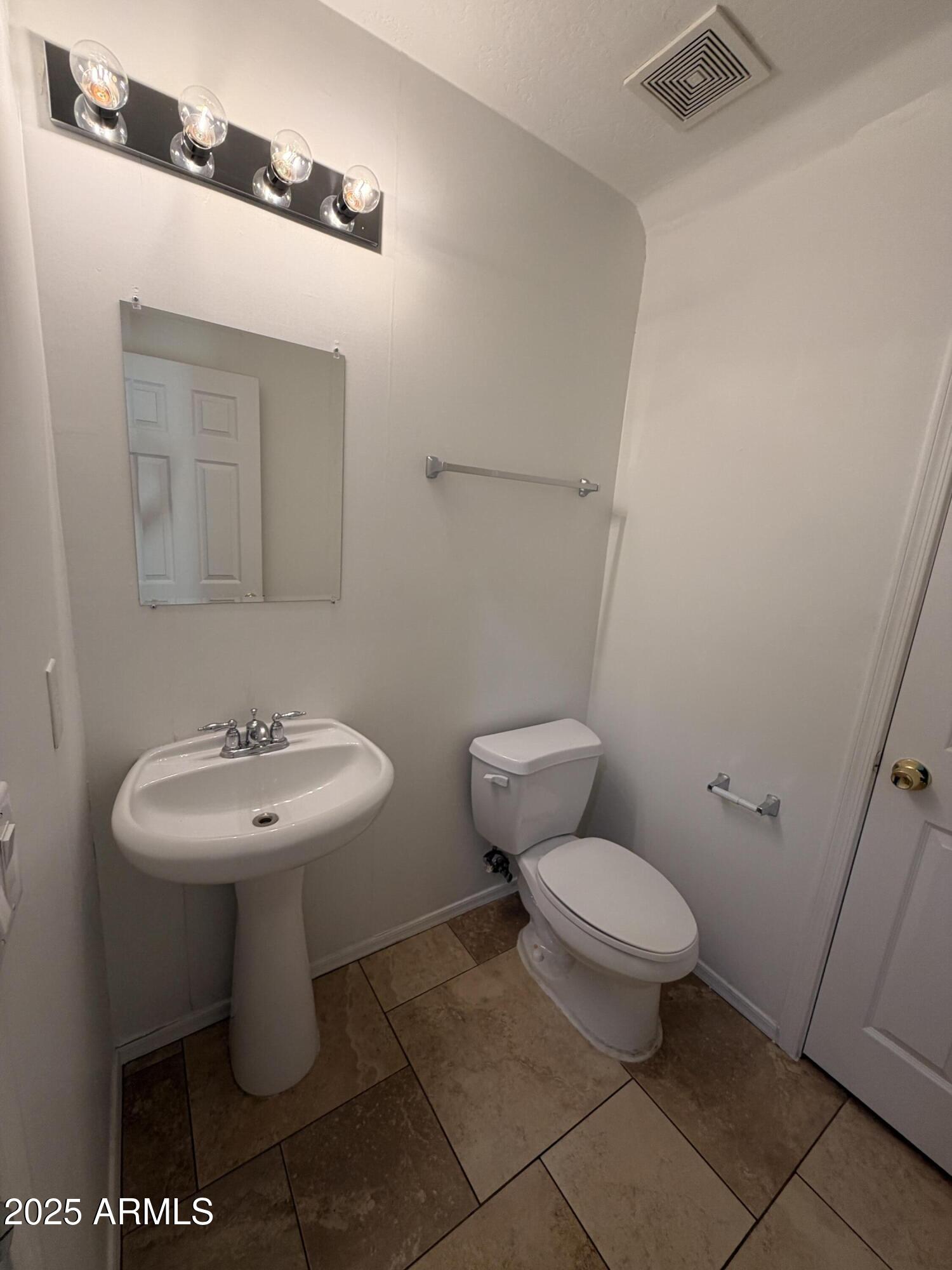 10027 West Payson Road Tolleson, AZ 85353 - Photo 6 of 18 a bathroom with a sink toilet and a mirror