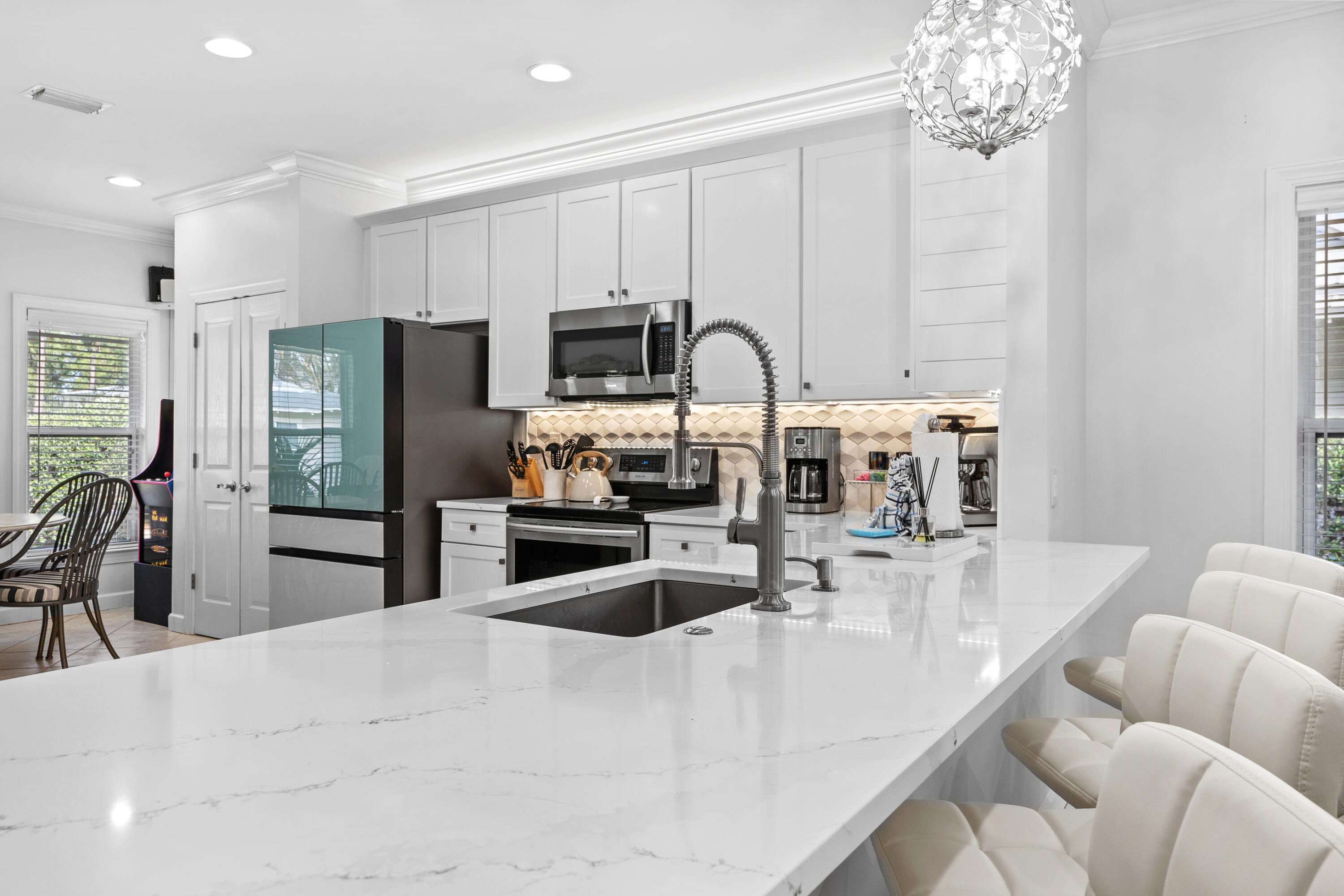 Undisclosed Address Miramar Beach, FL 32550 - Photo 10 of 51 a kitchen with stainless steel appliances kitchen island granite countertop a refrigerator a stove a sink a dining table and chairs with wooden floor