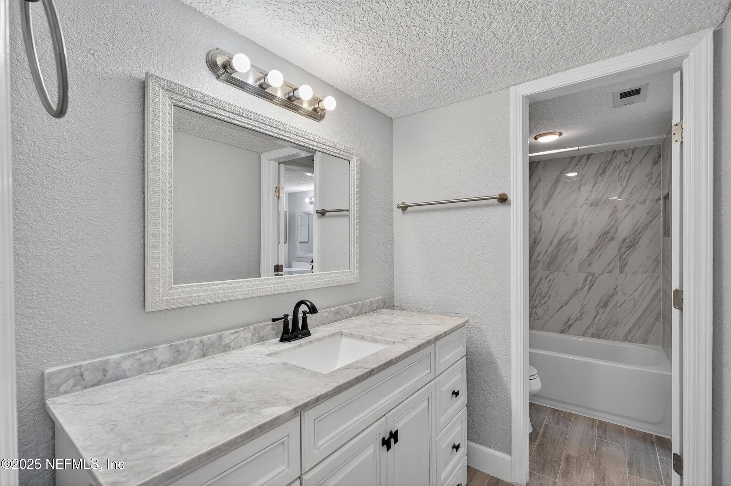 3913 Mission Drive, Unit 4 Jacksonville, FL 32217 - Photo 15 of 26 a bathroom with a granite countertop sink a mirror and a bathtub
