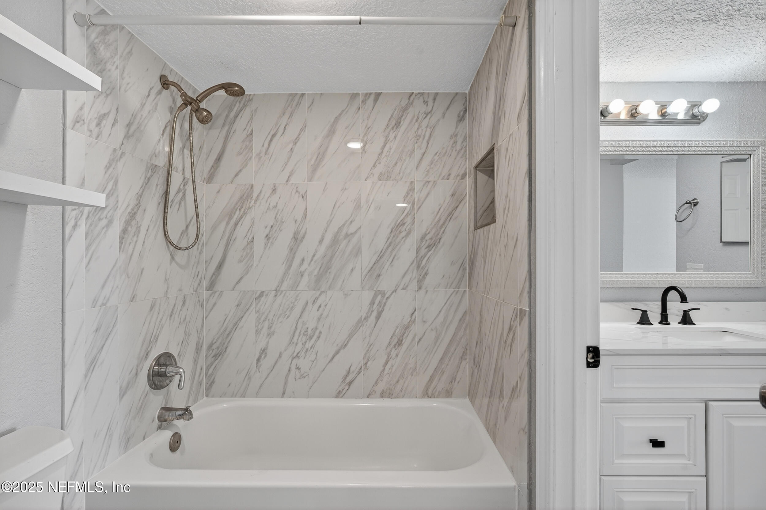 3913 Mission Drive, Unit 4 Jacksonville, FL 32217 - Photo 16 of 26 a bathroom with a tub sink vanity and a mirror