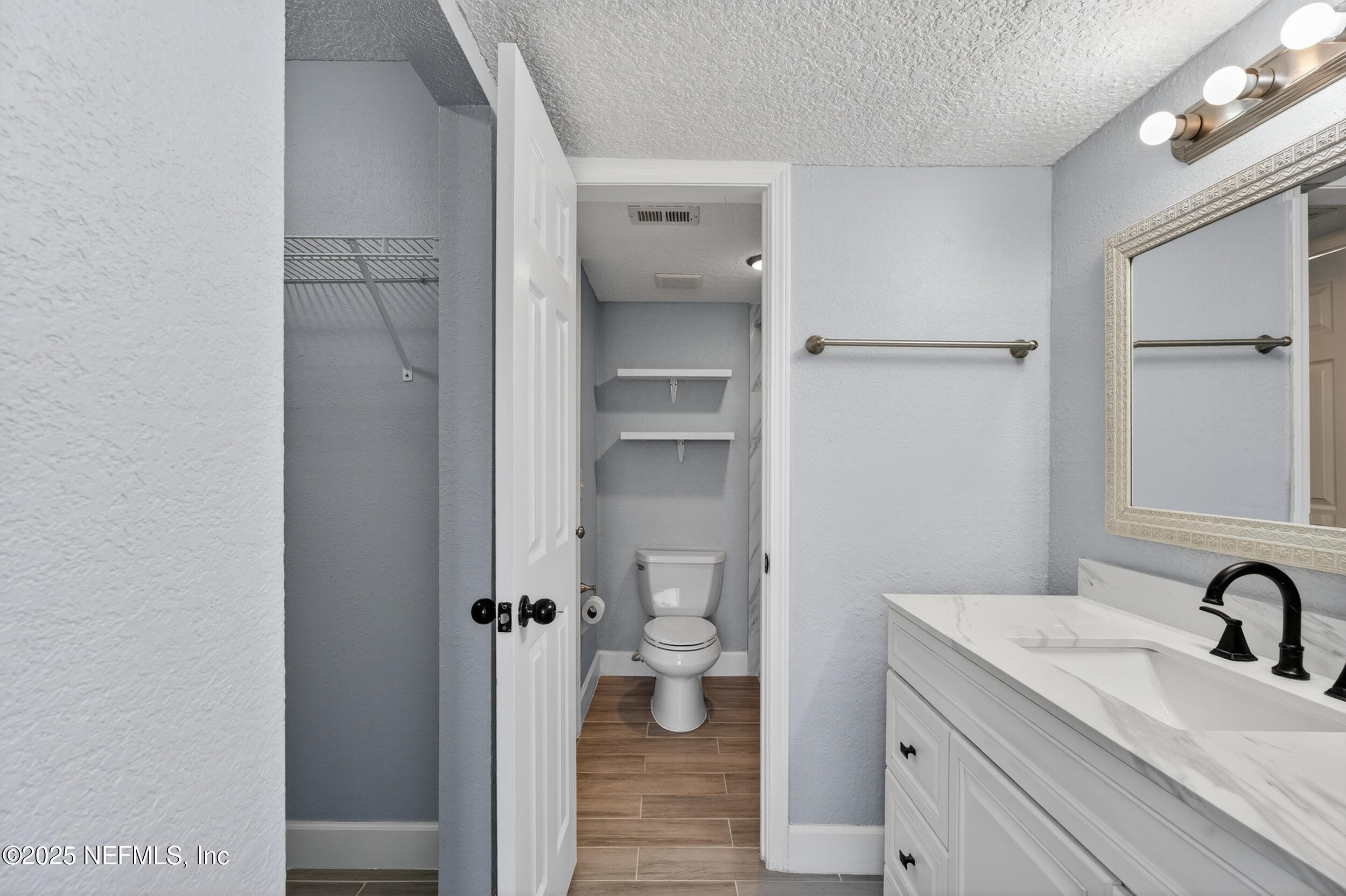 3913 Mission Drive, Unit 4 Jacksonville, FL 32217 - Photo 17 of 26 a bathroom with a granite countertop toilet a sink and a mirror