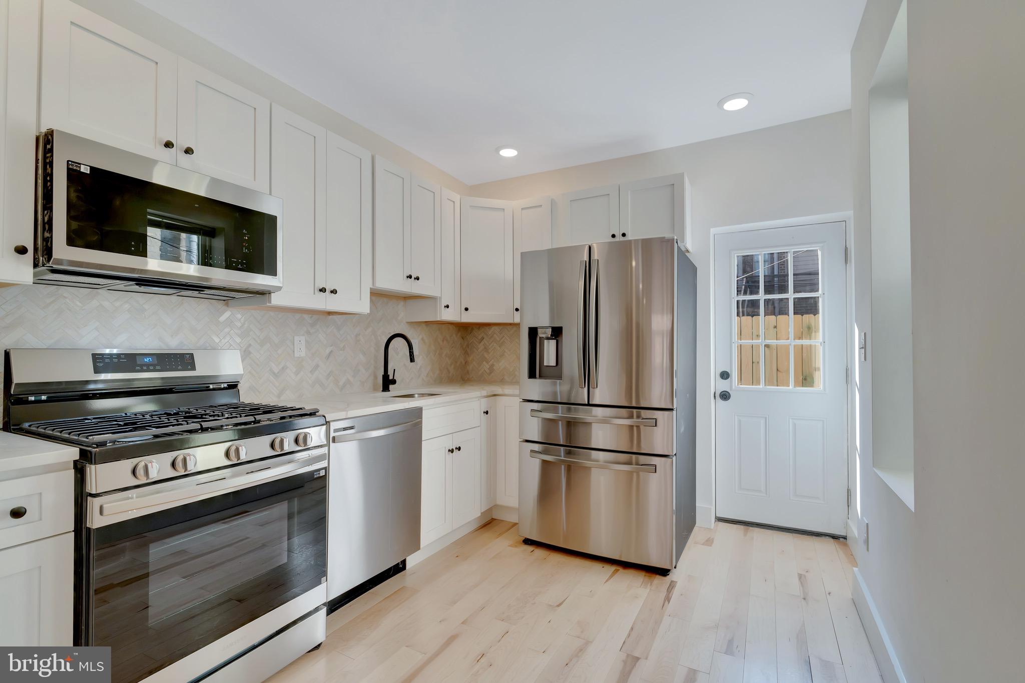 2138 Cross Street Philadelphia, PA 19146 - Photo 7 of 23 a kitchen with stainless steel appliances a stove a microwave and a refrigerator