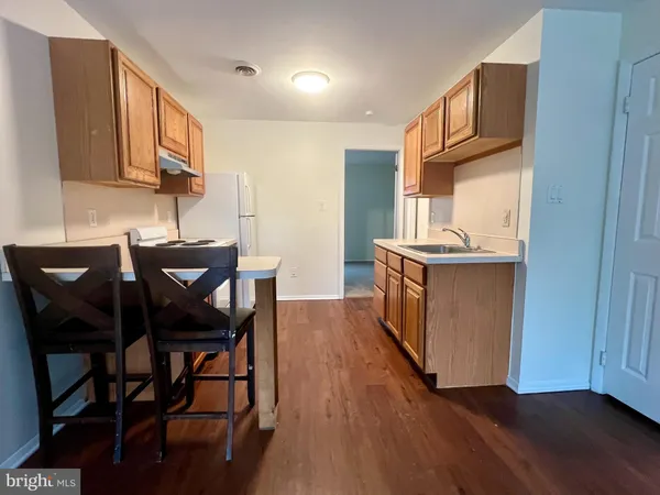 a kitchen with stainless steel appliances granite countertop a table chairs sink and cabinets
