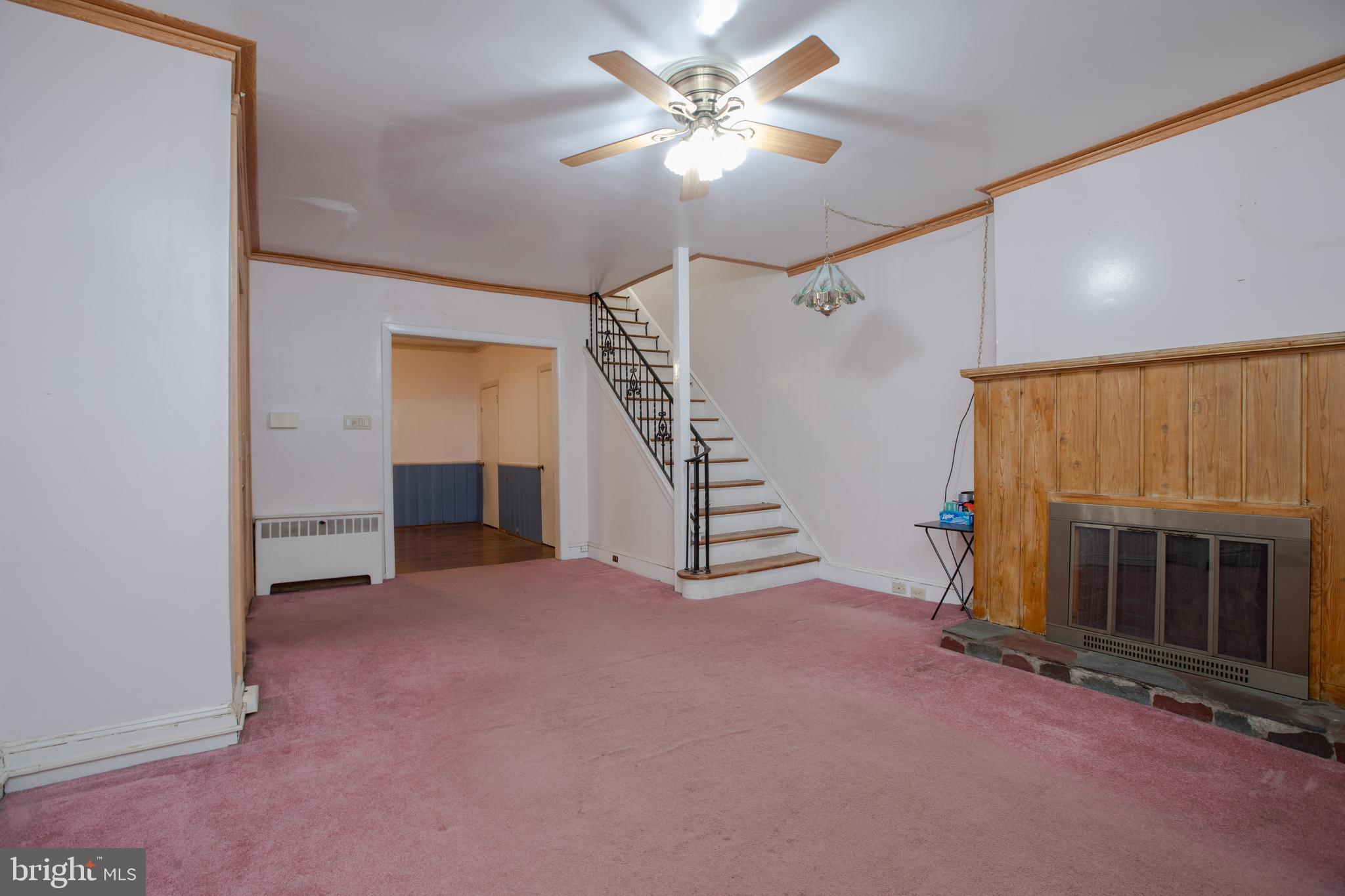 1530 Riverside Drive Trenton, NJ 08618 - Photo 4 of 36 a view of an empty room with fireplace stairs and a chandelier fan