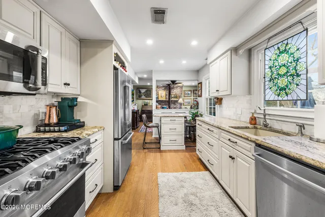 a kitchen with stainless steel appliances a refrigerator sink and microwave
