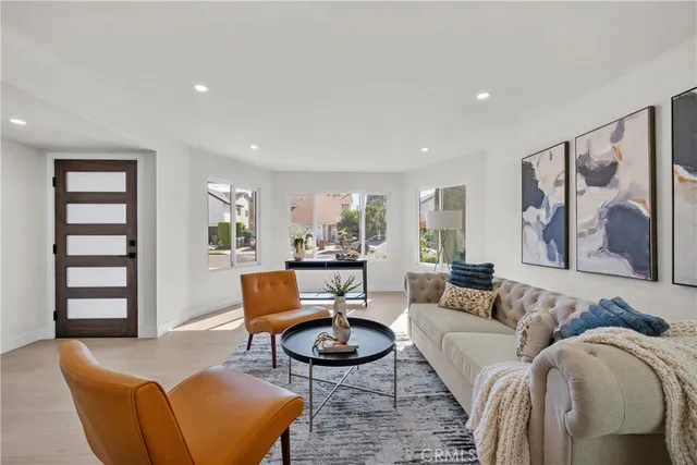 a living room with furniture a rug and wall painting